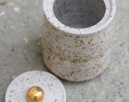 Speckled jar with gold handle.